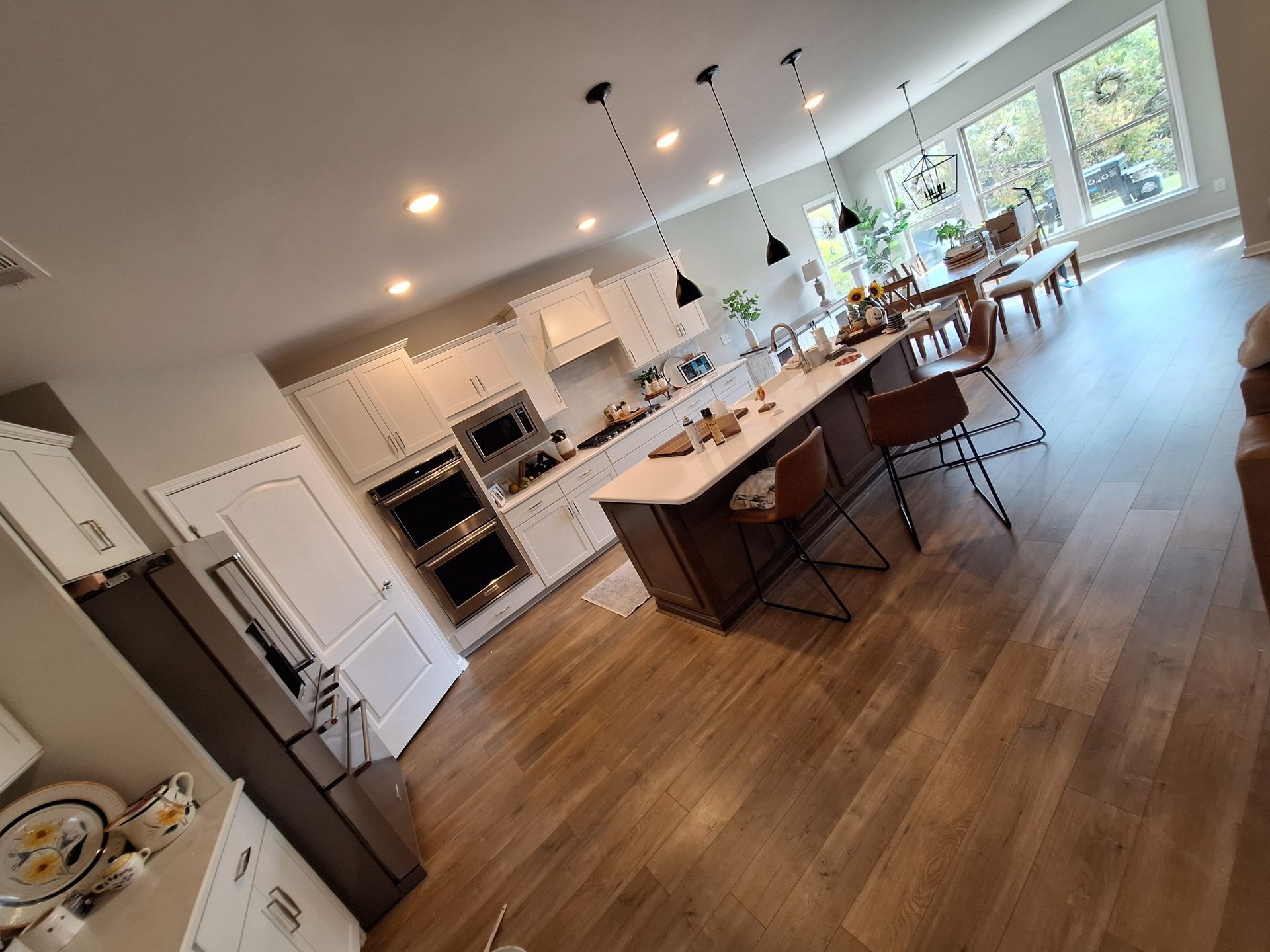 Modern open-plan kitchen and dining area with wooden floors and pendant lighting.